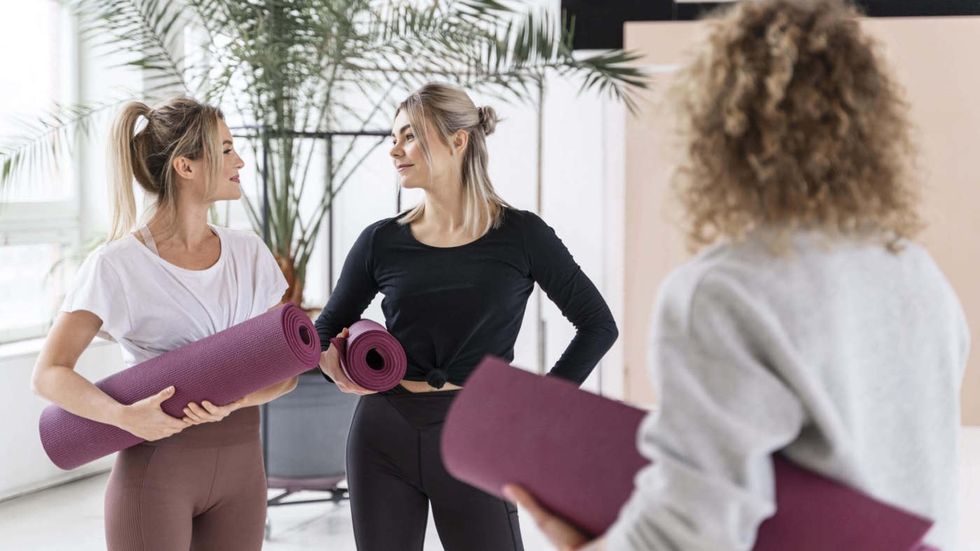 women-holding-yoga-mats-medium-shot-min
