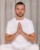 a man in white sportswear is doing yoga with a fitness room. the concept of a healthy lifestyle.